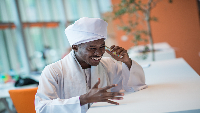Sudanese business man in traditional outfit using mobile phone in office
